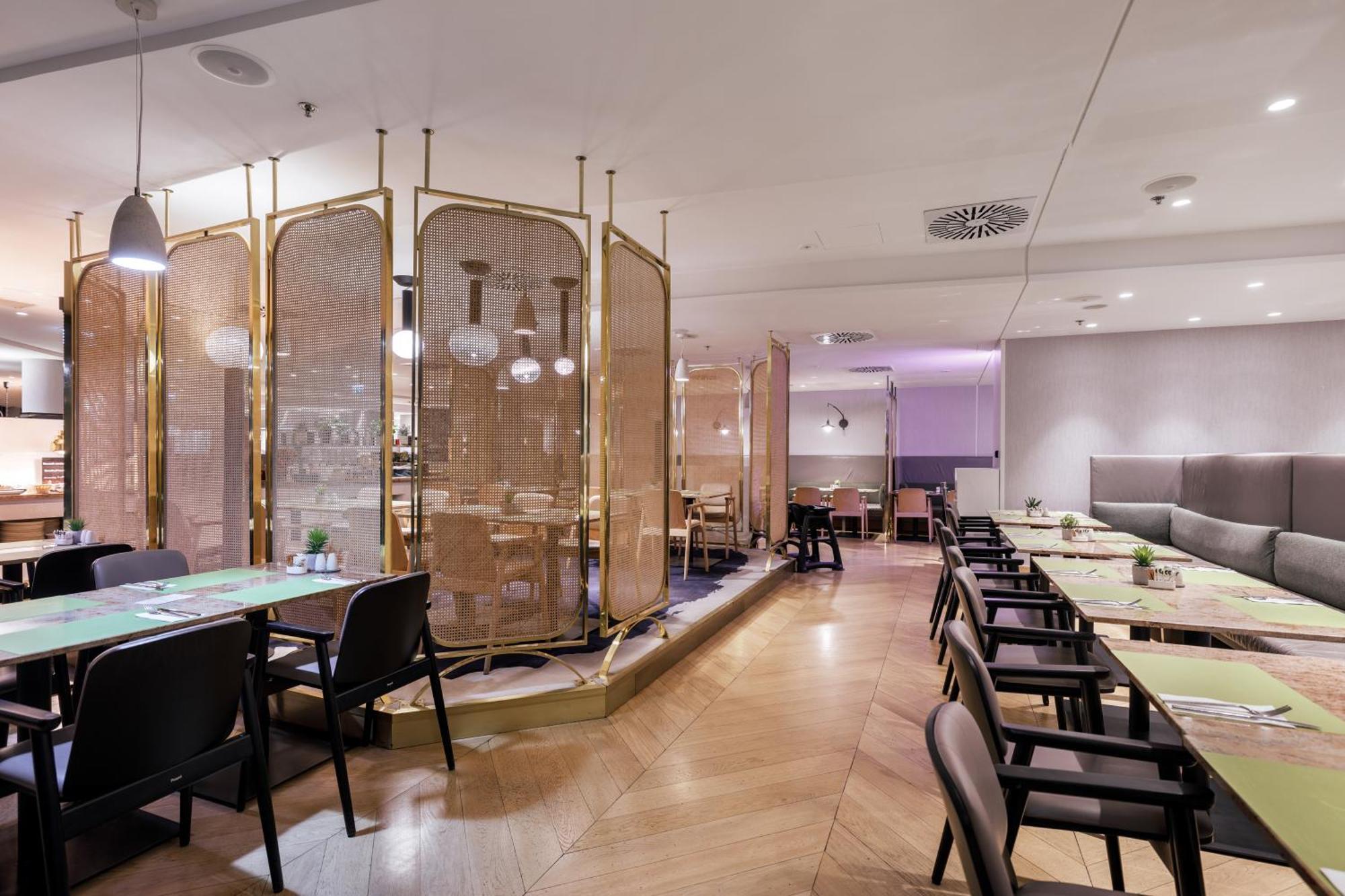Radisson Blu Resort Świnoujście מראה חיצוני תמונה The photo depicts a modern restaurant interior. It features a layout with several tables and chairs arranged in an organized manner. There is a decorative partition made of delicate mesh or fabric, providing some privacy between different dining area