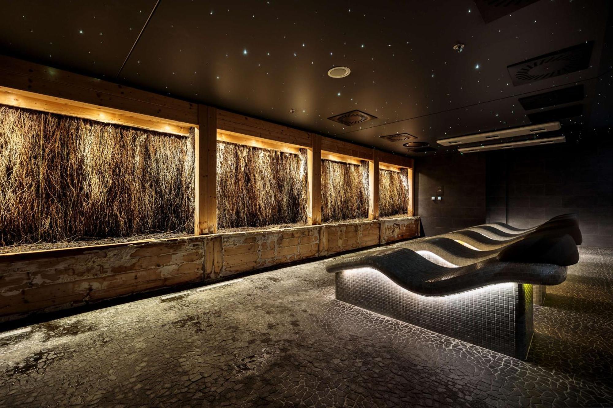Radisson Blu Resort Świnoujście מראה חיצוני תמונה The photo depicts a modern, serene spa or relaxation space. It features several wooden-framed windows that showcase natural elements, possibly dried grass or plants, creating a calming atmosphere. The walls are dark, and the ceiling may have lights r